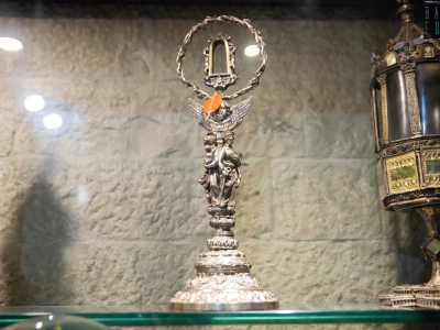 Ad attirare la nostra attenzione c�� anche un reliquiario a forma di corona d�argento intrecciata e retta da un piede in ottone sormontato da figure umane e angeliche